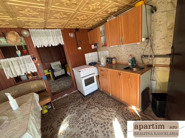 Küche mit Holzdekor, Sofa und Teppich in den Gärten.