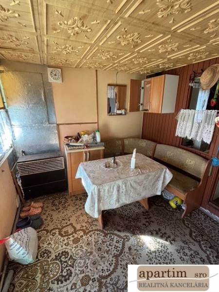 Das Innere der Hütte mit einem antiken gemusterten Tisch und Holzelementen in den Gärten.