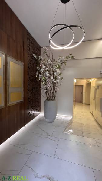 Büros mit einer Vase mit Trockenblumen, Holzdekorationen und interessanter Beleuchtung über dem Eingang.