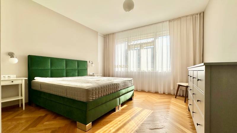 Schlafzimmer in einer 3-Zimmer-Wohnung mit Bett, Holzboden und Kommode.