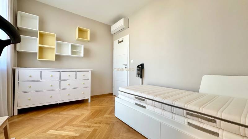Kinderzimmer in einer 3-Zimmer-Wohnung mit Bett, Kommode und Regalen, Boden mit Holzdekor.