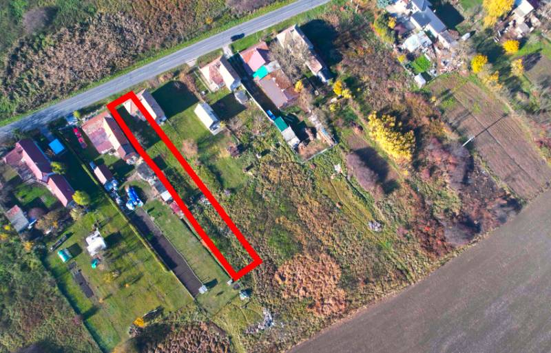 Luftperspektive auf Wohnbaugrundstücke in der Gemeinde Radnovce mit Hauptstraße.