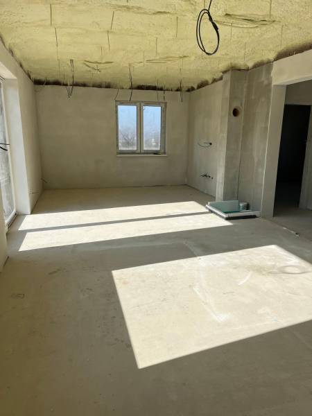 Ein geräumiges Zimmer in einem Einfamilienhaus in der Vyšná Šebastová Straße mit rohem Putz und Kabeln.