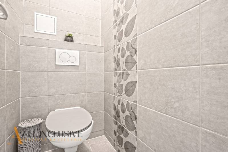 Toilette mit dekorativen Fliesen und Blumenmuster in einer 3-Zimmer-Wohnung.