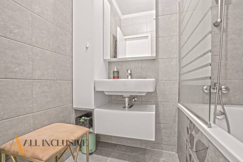 Badezimmer in einer 3-Zimmer-Wohnung mit Badewanne, Waschbecken und Stauraum.