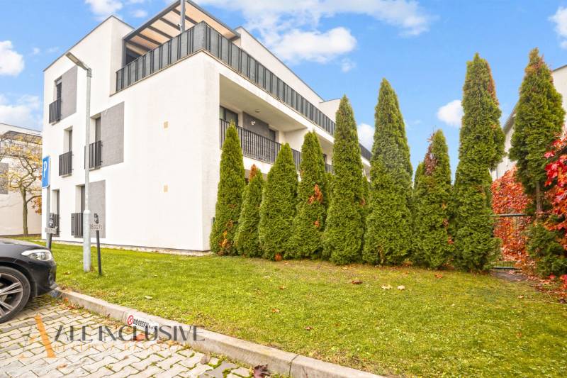 Außenbereich eines modernen Wohnhauses in Dunajská Streda mit privaten Balkonen und Bäumen.