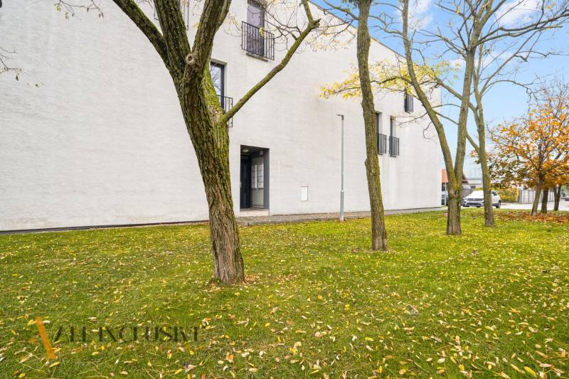 Außenbereich einer 3-Zimmer-Wohnung in Dunajská Streda mit Rasen und Bäumen im Herbst.