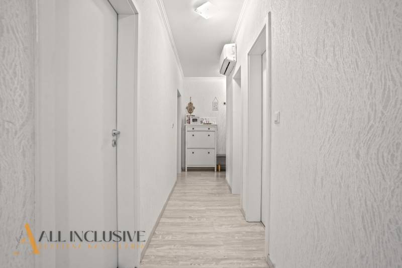 Flur in einer 3-Zimmer-Wohnung mit Holzboden und Klimaanlage.