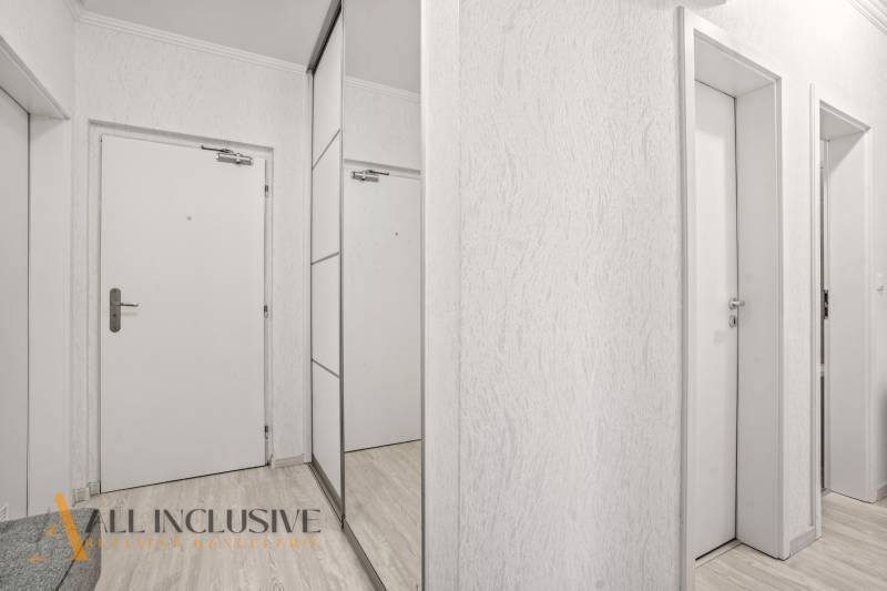 Weiße Innentüren und ein Spiegelschrank in einer 3-Zimmer-Wohnung mit einem Boden in Holzoptik.