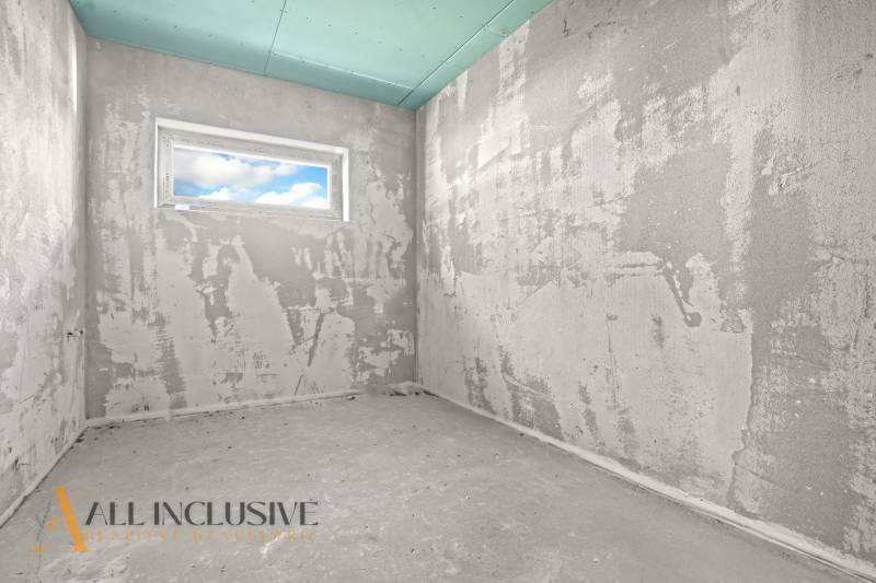 Rohbau eines Zimmers in einem Einfamilienhaus mit Fenster und unbearbeiteten Wänden.