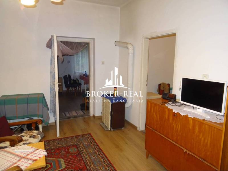 Wohnzimmer in einem Einfamilienhaus mit Teppich und Boden in Holzoptik.