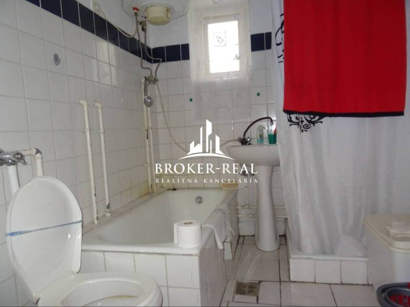 Badezimmer mit Badewanne und weißen Fliesen in einem Einfamilienhaus.