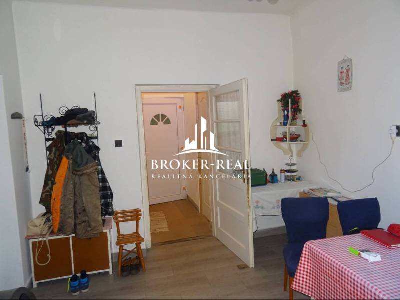 Innenraum eines Einfamilienhauses mit Holzboden, Esstisch und Kleiderständer.