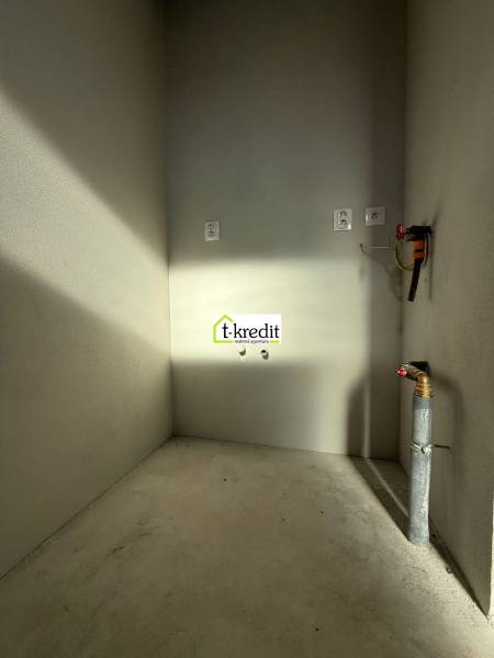 Ein leerer Raum mit Betonboden und Installationen in einem Einfamilienhaus.