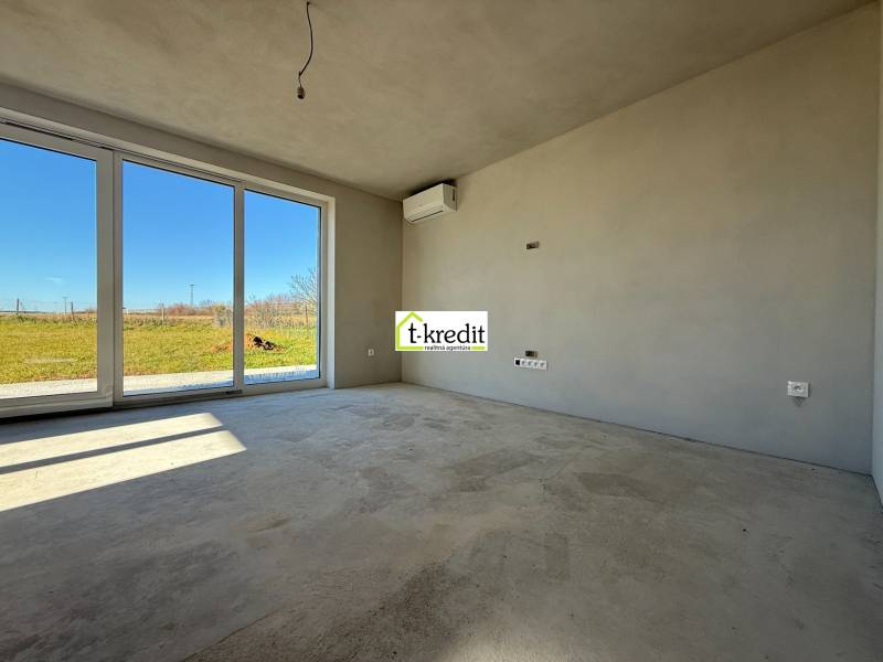 Ein geräumiges Zimmer in einem Einfamilienhaus mit großen Fenstern und Blick auf den Garten.