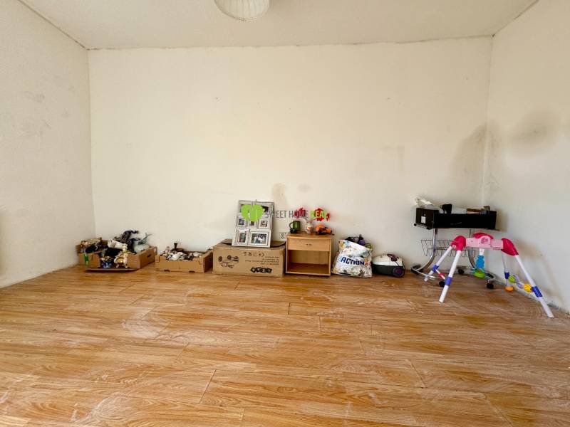 Ein Zimmer in einem Einfamilienhaus mit Wänden voller Spielzeug und einem Boden mit Holzdekor.