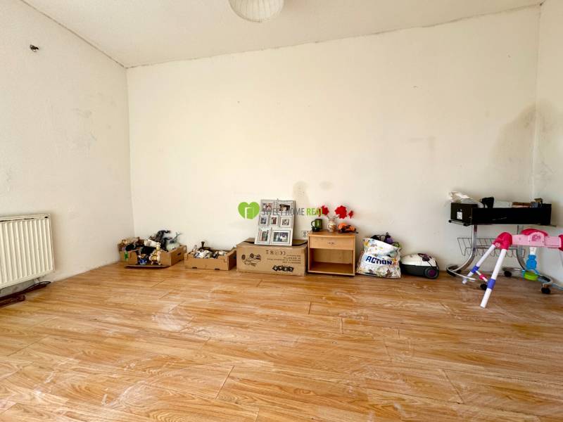 Ein Zimmer in einem Einfamilienhaus mit einem Holzboden und verschiedenen Gegenständen an der Wand.