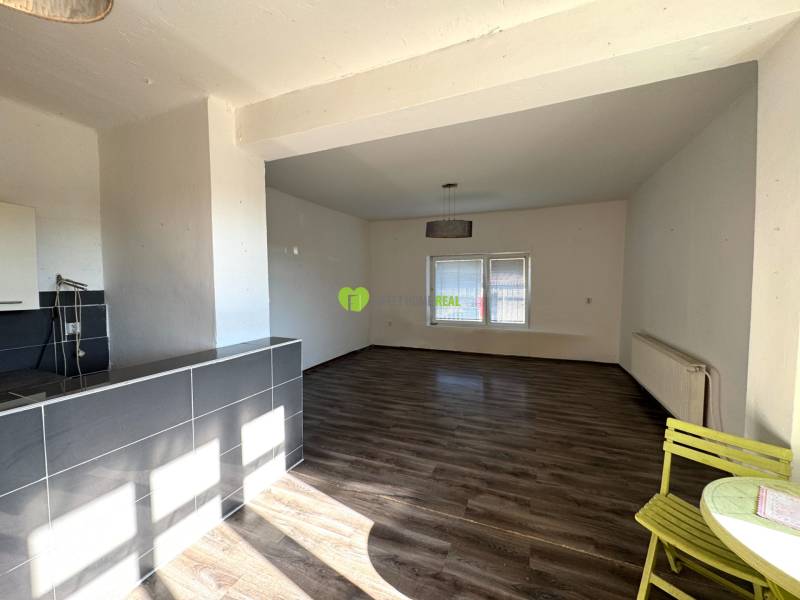 Innenraum eines Einfamilienhauses mit geräumigem Zimmer, Holzboden und Essecke.