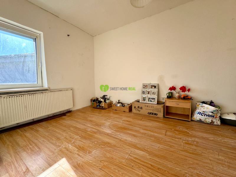 Ein Zimmer in einem Einfamilienhaus mit einem Holzboden und Möbeln.