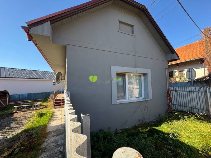 Ein Einfamilienhaus in der Varovecká-Straße in Družstevná pri Hornáde mit einem Rasen-Garten und einem Blechzaun.