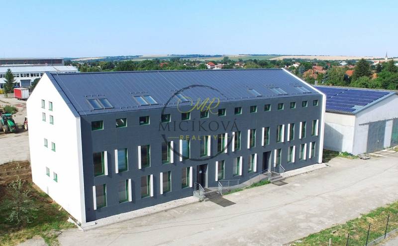 Das Gebäude in der Levická-Straße in Vráble mit Büros, moderner Architektur und grüner Umgebung.