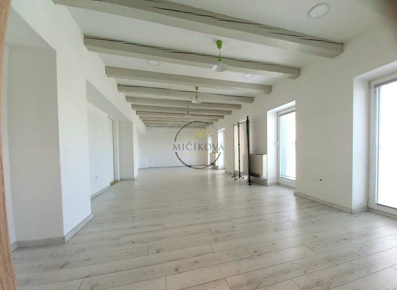 Helle Büros mit Holzboden und großen Fenstern.