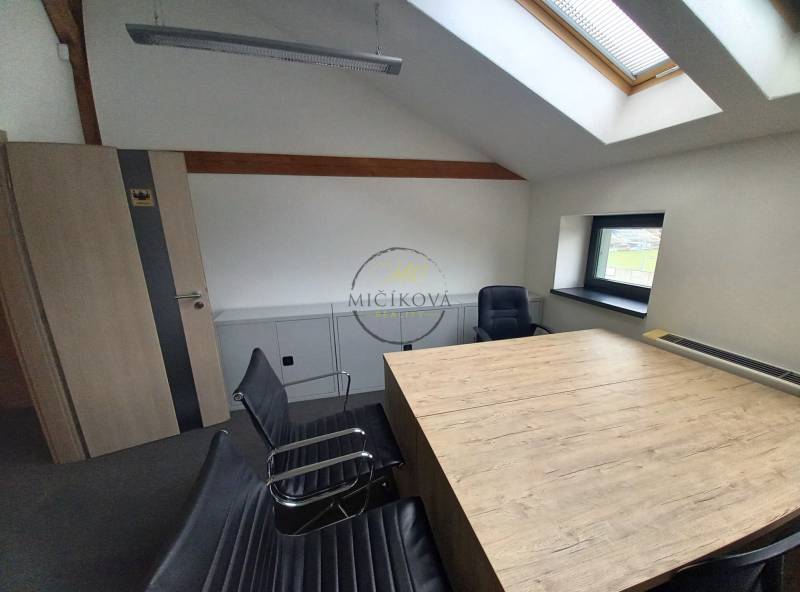 Innenraum eines Büros mit Konferenztisch und Stühlen, Boden mit Holzdekor.