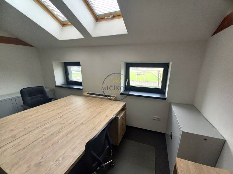 Büros mit Holzboden, Dachfenstern und Schreibtischen.