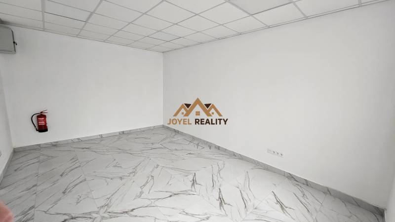 Geschäftsräume mit Marmorboden und Feuerlöscher an der Wand.