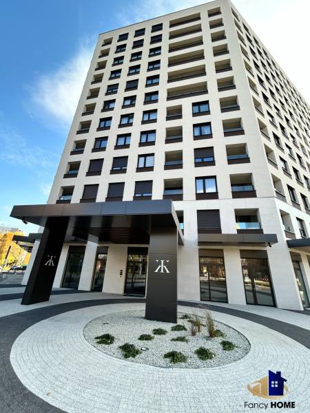 Ein Hochhaus in der Karpatská-Straße in Poprad mit modernem Eingang und geschwungenen Gehwegen.