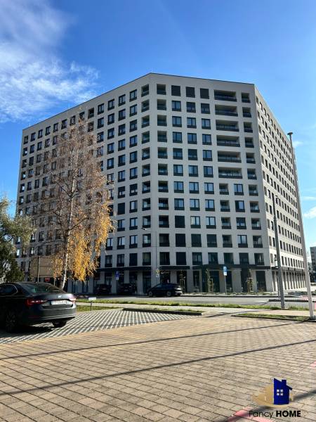 Wohnhaus in der Karpatská-Straße in Poprad, umliegender Parkplatz und Bäume.