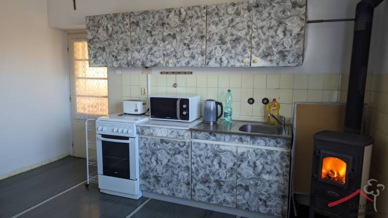 Küche mit Fliesen, Herd und Kamin in einem Einfamilienhaus, Boden mit Holzdekor.