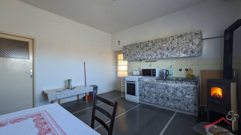 Eine Küche in einem Einfamilienhaus mit einem Ofen und einer Küchenzeile, Boden mit Holzdekor.