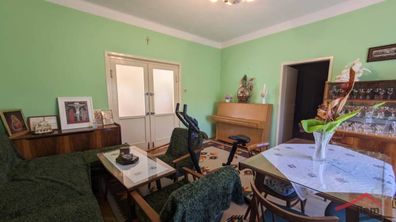 Wohnzimmer in einem Einfamilienhaus mit Möbeln, Fitnessgeräten und grünen Wänden.