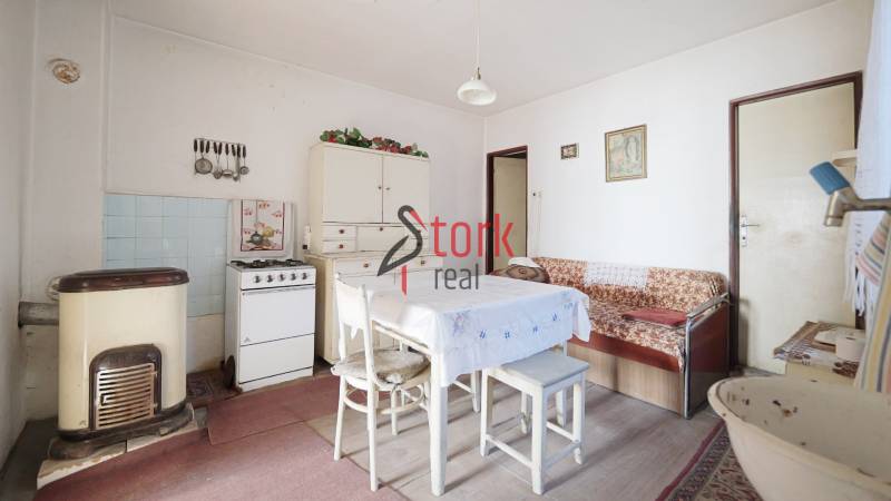 Esszimmer mit Gasherd, Tisch und Sofa in einem Einfamilienhaus, Boden mit Holzdekor.