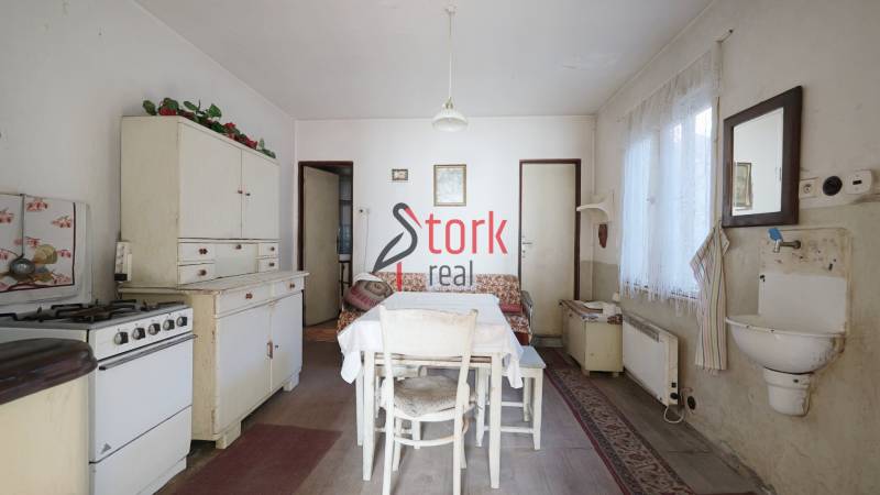 Küche in einem Einfamilienhaus mit Retro-Möbeln, Tisch und Spüle, Boden mit Holzdekor.