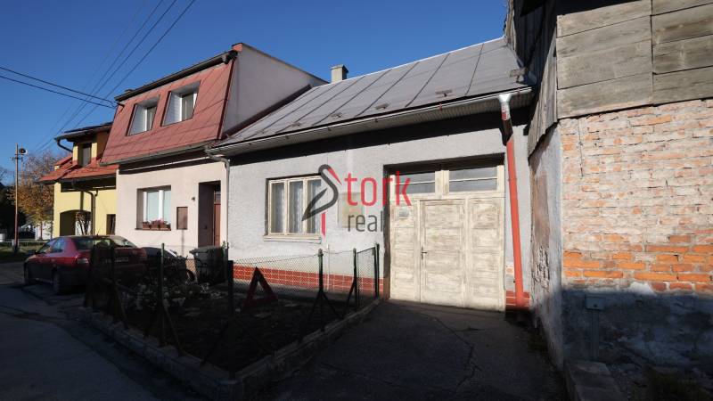Ein Einfamilienhaus in der Kostolná-Straße in Rajec mit einem Auto davor und einem Holzzaun.