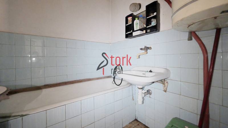 Badezimmer mit Badewanne, Waschbecken und blauen Fliesen in einem Einfamilienhaus.