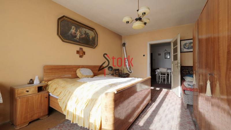 Schlafzimmer in einem Einfamilienhaus mit Holzmöbeln, einem Bild und einem Kronleuchter.