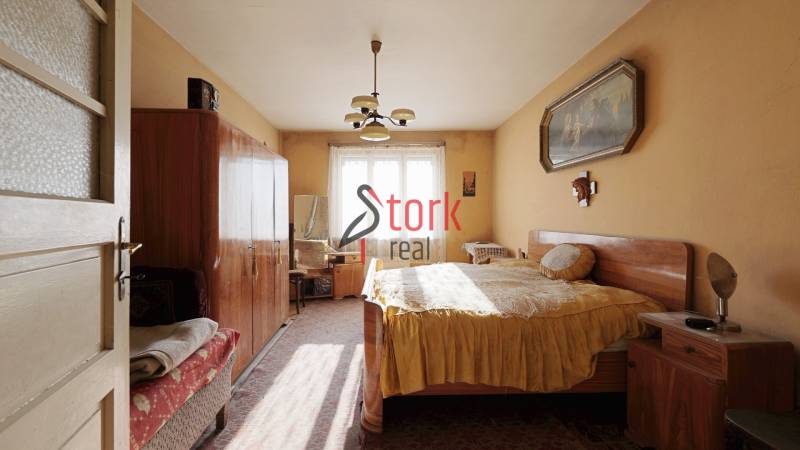 Schlafzimmer im Einfamilienhaus mit Möbeln, Kronleuchter und Bild an der Wand.