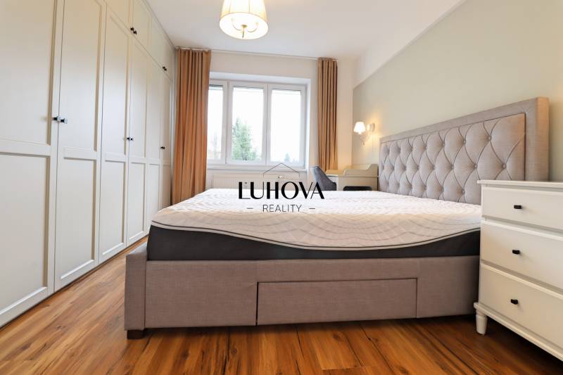 Helles Schlafzimmer mit großem Bett, Einbauschrank und Holzboden in einer 3-Zimmer-Wohnung.