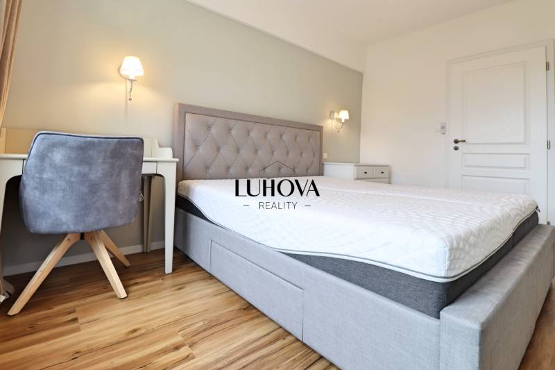 Schlafzimmer in einer 3-Zimmer-Wohnung mit einem komfortablen Bett und einem Boden in Holzoptik.