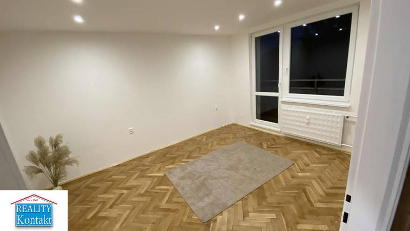 Ein Zimmer in einer Einzimmerwohnung mit einem Holzboden und einem großen Fenster.