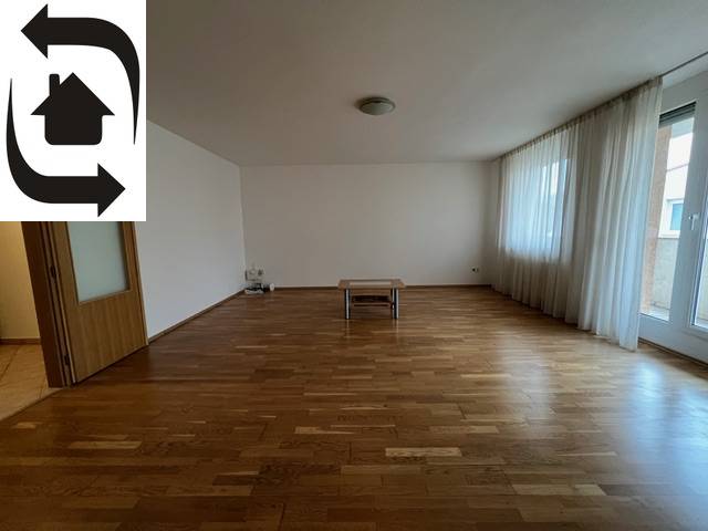Geräumiges Wohnzimmer mit Holzboden und Fenstern in einer 3-Zimmer-Wohnung.