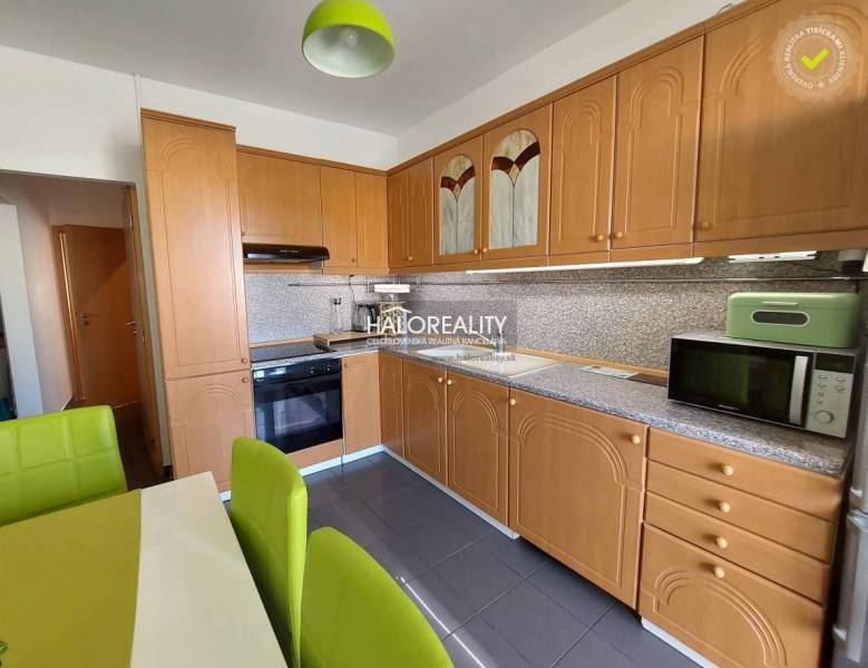 Küche in einer 3-Zimmer-Wohnung mit Holzküche und grünen Stühlen.