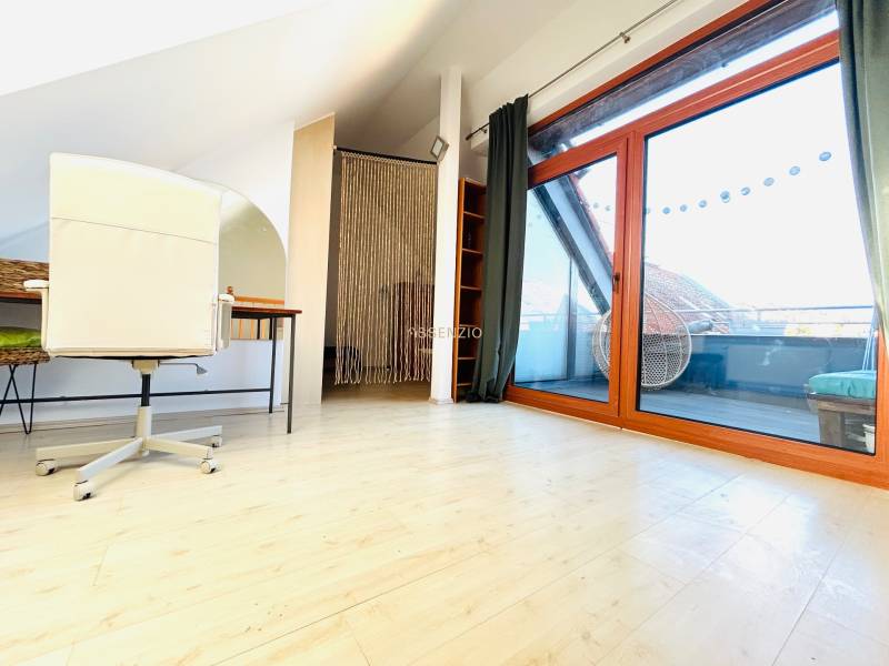 Arbeitszimmer in einer 2-Zimmer-Wohnung mit Holzboden und Balkontüren.