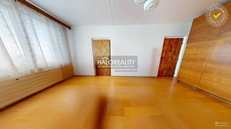 Ein Zimmer in einer 3-Zimmer-Wohnung mit Holzboden, großem Fenster und Einbauschrank.