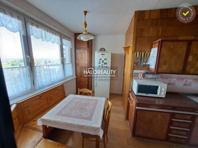 Wohnzimmer in einer 3-Zimmer-Wohnung mit Holzboden, Sofa und Wanddekorationen.