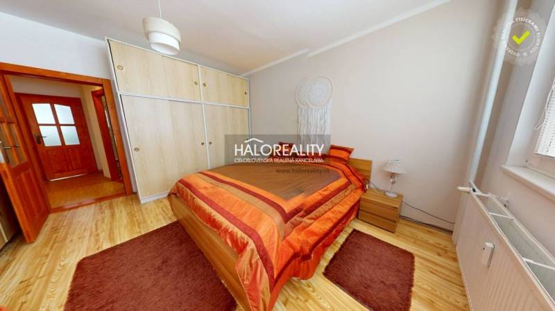 Helles Schlafzimmer in einer 2-Zimmer-Wohnung mit Holzboden und Einbauschrank.