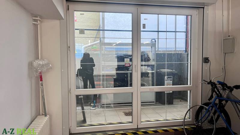 Glastüren in Geschäftsräumen, Fahrrad, Heizkörper und Plastikfolie an der Wand.